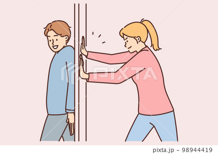 Positive man hides behind door preventing girlfriend from passing or arranging prank Positive man hides behind door preventing girlfriend from passing or arranging prank 98944419