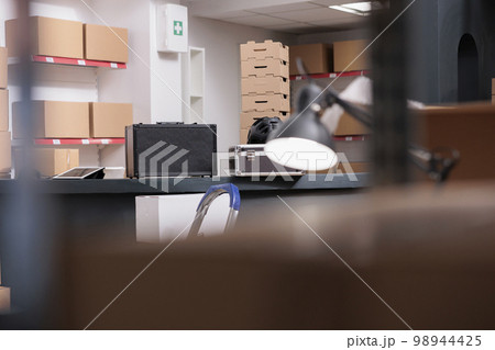 Empty interior of new large and modern storehouse space full with tall shelves completely filled with carton boxes and containers. Warehouse is a commercial building for storage of goods. 98944425
