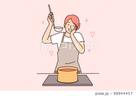Happy housewife woman cooks soup standing at stove with saucepan and tastes after adding spices Happy housewife woman cooks soup standing at stove with saucepan and tastes after adding spices 98944457