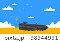 A destroyed tank in front of a yellow field and blue sky 98944991