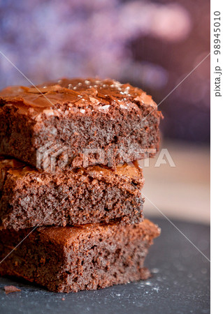 Dark chocolate brownies stack, lavender flowers Dark chocolate brownies stack, lavender flowers 98945010