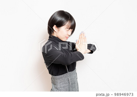 お願いしている若い女性 98946973