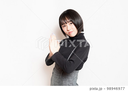 お願いしている若い女性 98946977