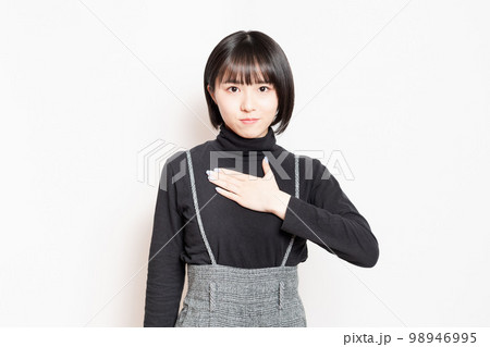 胸に手を当てている若い女性 胸に手を当てている若い女性 98946995