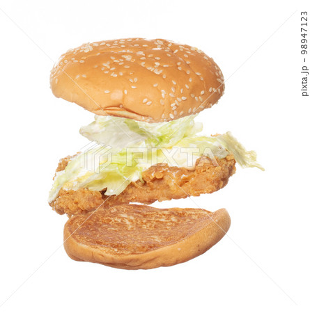Fried Chicken Burger fly explosion, Chicken Burgers vegetable fall down. Hot bread chicken burger fast food throw splash in air. White background Isolated high speed shutter, freeze action 98947123