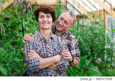 Portrait of happy elderly couple in the greenhouse Portrait of happy elderly couple in the greenhouse 98947906