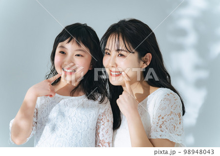 歯を見せる女性と女の子　親子のデンタルケアイメージ 98948043