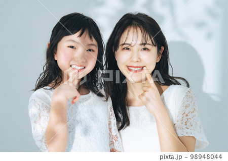 歯を見せる女性と女の子　親子のデンタルケアイメージ 98948044