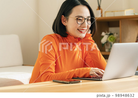 自宅でパソコンを見る女性 98948632