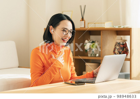 オンラインでパソコンに向かって話す女性 オンラインでパソコンに向かって話す女性 98948633