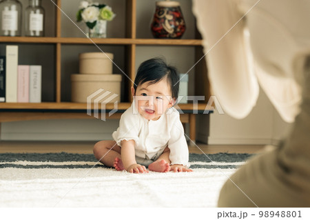 家のリビングで座る赤ちゃん 98948801