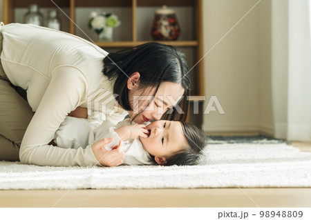 家のリビングで赤ちゃんをあやすママ 家のリビングで赤ちゃんをあやすママ 98948809
