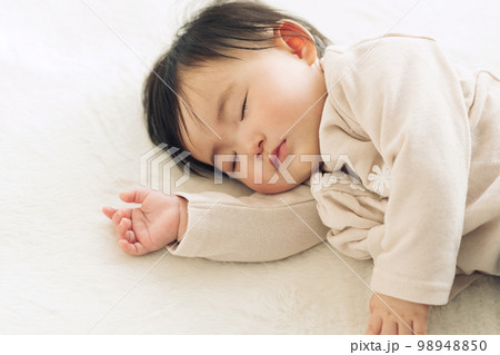 ラグでお昼寝する0歳児の赤ちゃん 98948850