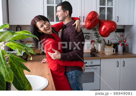 Man and woman in love date at home in kitchen happy hugs. Valentine's Day, happy couple, love story. Love nest, housing for young family 98949081