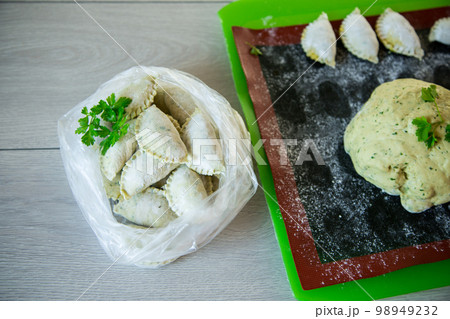 Raw green dough dumplings with parsley, dill. 98949232