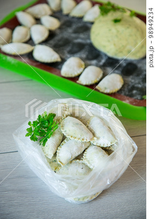 Raw green dough dumplings with parsley, dill. 98949234