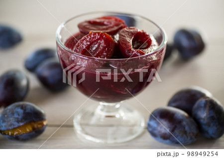Sweet plums in syrup, in a glass bowl . 98949254