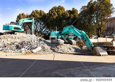 団地の解体工事現場　重機バックホーとダンプカー 98949494