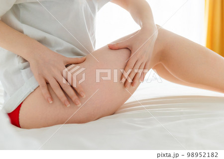 Close-up of female feet. Woman massages and shows her beautiful smooth legs. Copy space. Concept of laser epilation and varicosity Close-up of female feet. Woman massages and shows her beautiful smooth legs. Copy space. Concept of laser epilation and varicosity 98952182