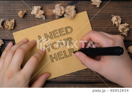 Person writes words I Need Your Help on card on table Person writes words I Need Your Help on card on table 98952654