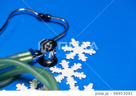 Christmas and New Year Medicine - Stethoscope and Snowflakes on a Blue Background, place for text. Christmas and New Year Medicine - Stethoscope and Snowflakes on a Blue Background, place for text. 98953092