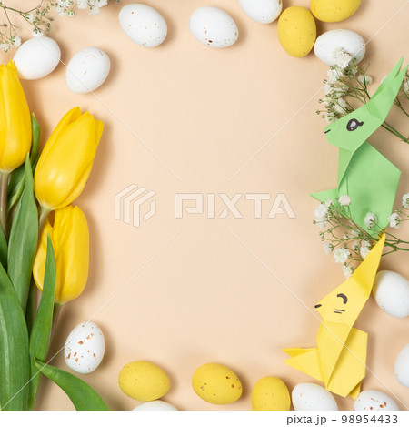 Happy Easter - layout with space for text center, Easter bunnies made of origami paper and eggs, top view Happy Easter - layout with space for text center, Easter bunnies made of origami paper and eggs, top view 98954433