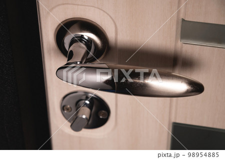 Entrance door handle close up. Lock and handle on the door Entrance door handle close up. Lock and handle on the door 98954885