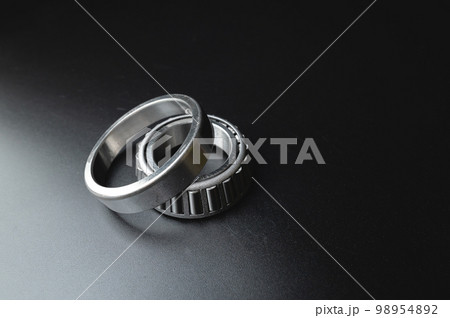 new two-piece roller bearing on a black background. Metal spare part for car suspension 98954892