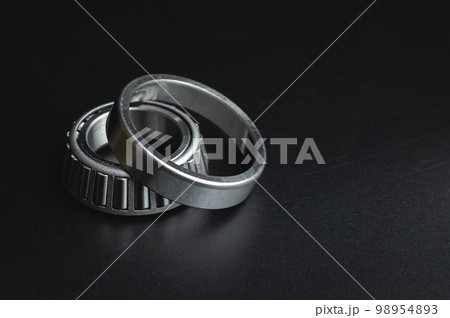 new two-piece roller bearing on a black background. Metal spare part for car suspension new two-piece roller bearing on a black background. Metal spare part for car suspension 98954893