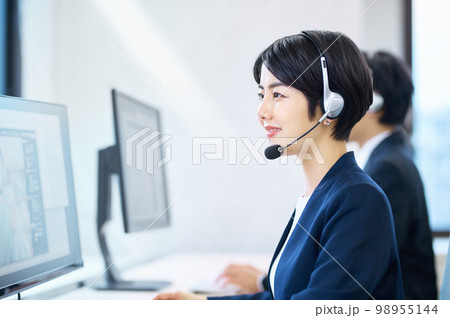 オフィスでヘッドセットをつけて対応するオペレーターの女性 98955144