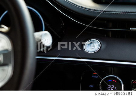 Engine start button. Close up engine car start stop button. Modern car interior details. Engine start button. Close up engine car start stop button. Modern car interior details. 98955291