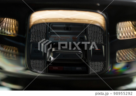 Close up image of the SOS button and car ceiling lamp in a car. Close up image of the SOS button and car ceiling lamp in a car. 98955292