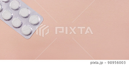 The tablets are packaged on a beige light background with a place copy space to text a banner for a medical clinic. Medicine and pharmacy, disease treatment The tablets are packaged on a beige light background with a place copy space to text a banner for a medical clinic. Medicine and pharmacy, disease treatment 98956003