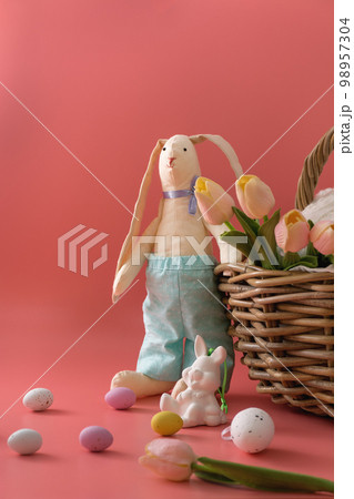 Easter bunny near basket and eggs 98957304