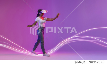Excited African American Lady Wearing Vr Headset Walking On Glowing Neon Lines 98957526