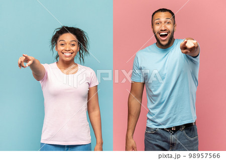 Hey, you. Joyful black couple pointing at camera, excited man and woman indicating somebody, pink and blue background 98957566
