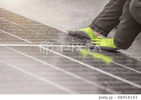 The solar panel installer connects the modules together. Installation work on the roof, connection and installation of solar panels with copy space 98958193