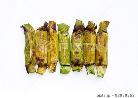 Grilled sticky rice in banana leaves with banana filling Grilled sticky rice in banana leaves with banana filling 98959565