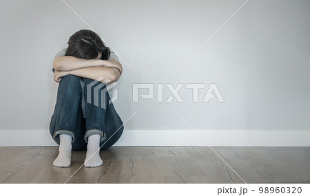 Sad woman sitting on a floor alone in empty room, despair and lonely concept with copy space Sad woman sitting on a floor alone in empty room, despair and lonely concept with copy space 98960320