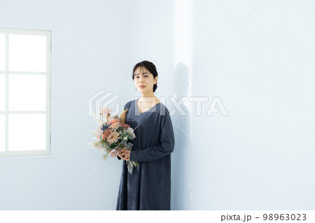 花束を持つグレーのワンピースの女性 98963023