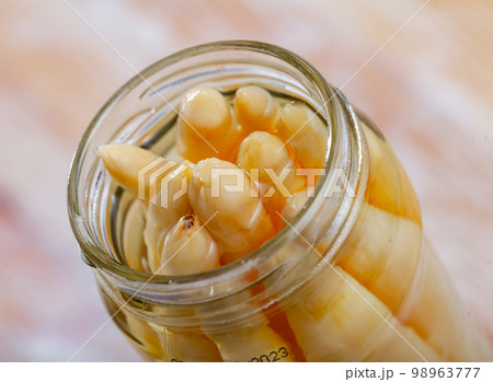 Closeup of pickled white asparagus in open jar Closeup of pickled white asparagus in open jar 98963777