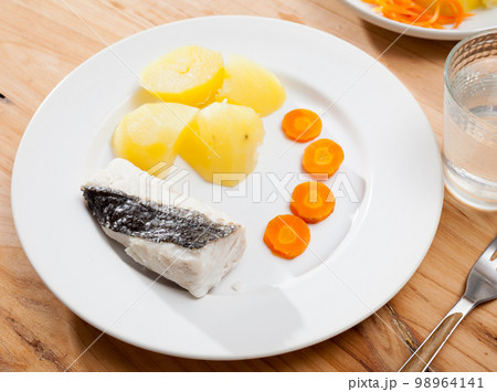 Codfish prepared on steam with potatoes and carrots at plate Codfish prepared on steam with potatoes and carrots at plate 98964141