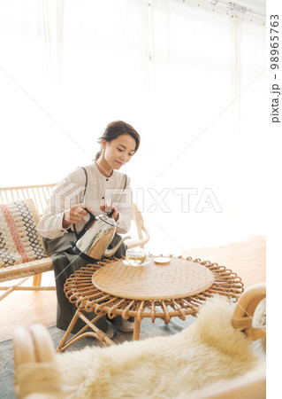 温かい飲み物を飲む女性 98965763