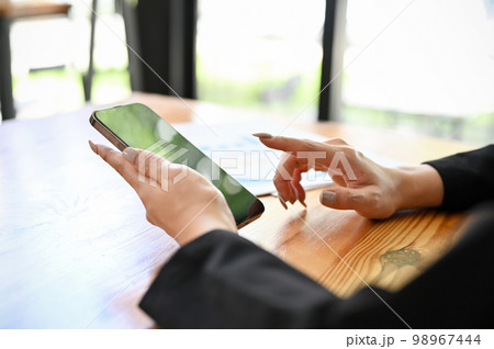 A female chatting with her friends on her smartphone. cropped shot 98967444