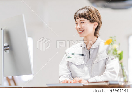 開放的なオフィスでパソコン作業をする女性エンジニア 98967541