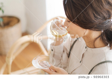 温かい飲み物を飲む女性 98968303