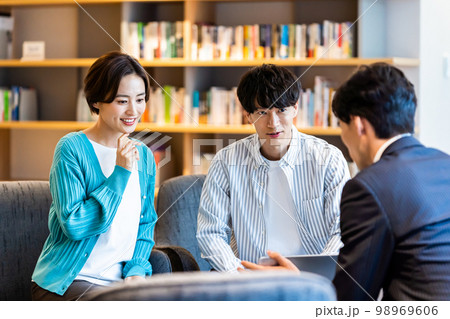 相談する若い夫婦 相談する若い夫婦 98969606