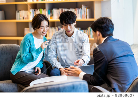 相談する若い夫婦 相談する若い夫婦 98969607