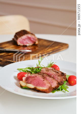 Juicy fried duck breast served on a plate with fresh arugula and corn salad 98971355