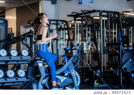 スポーツジムでトレーニングする若い女性 スポーツジムでトレーニングする若い女性 98971423